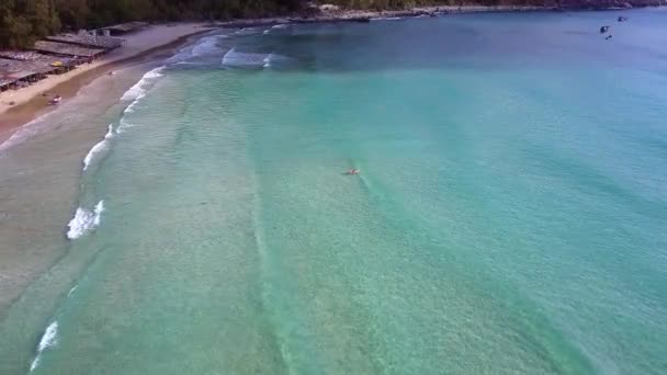 Mujer flota en el océano la captura de olas contra la costa — Vídeo de stock