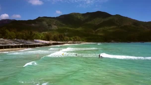 紺碧の海の丘足とサーファー初心者で日除けの美しい熱帯空撮大規模な砂のビーチ — ストック動画