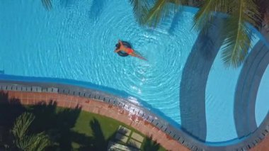 Panoramik ince kadın yüzme havuzu güneş ışığı altında lifebuoy üzerinde hafta sonu zaman harcıyor