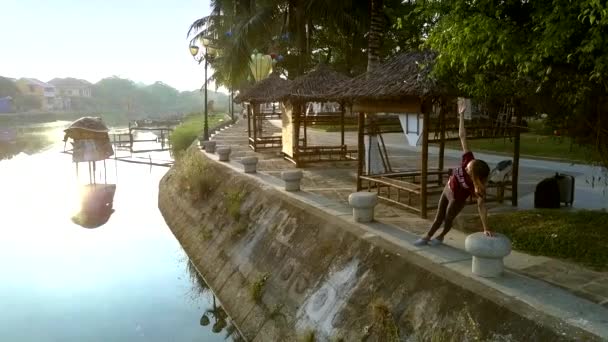 美丽的图片金发女孩做健身在河边与棕榈反射对老惠安河水 — 图库视频影像