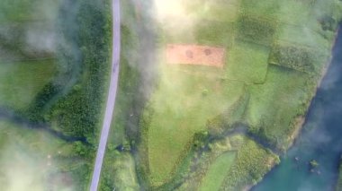 fantastik üst panorama güneş ışınları yol ve mavi nehir kenarında geçti yeşil vadi üzerinde parlak beyaz dinlenmek sis spot ışık