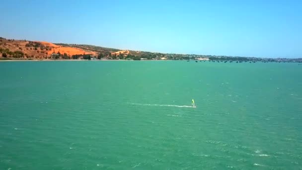 鸟瞰图风帆在无边的蓝天下乘坐蓝色海浪对抗绿色海岸 — 图库视频影像