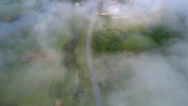Valle verde con pueblo de carretera viene a través de neblina de la mañana — Vídeo de stock