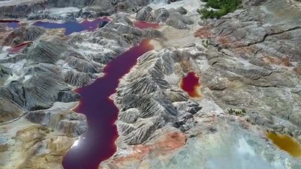 明るい太陽ディスク反射が紫の池の水から急な渓谷の間消える絵空撮粘土採石場周辺地域の斜面します — ストック動画