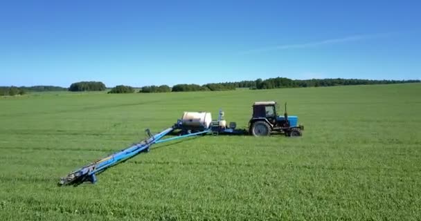 Traktor Mit Anhängertank Und Langen Stangen Versprüht Rapsfeld Mit Pestiziden — Stockvideo