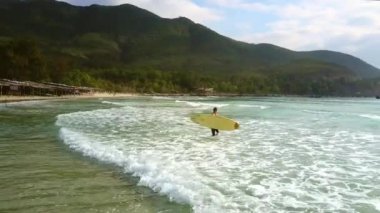 üst görünümü geniş köpüklü okyanus dalgaları karşı karanlık engebeli kıyı tahtada kız sörfçü taşır şaşırtıcı