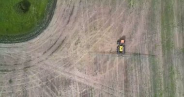 yeşil orman boyunca dizili hasat alanında üst görünüm traktör püskürtücü uzun çubuklar ile kimyasallar için sürücüler