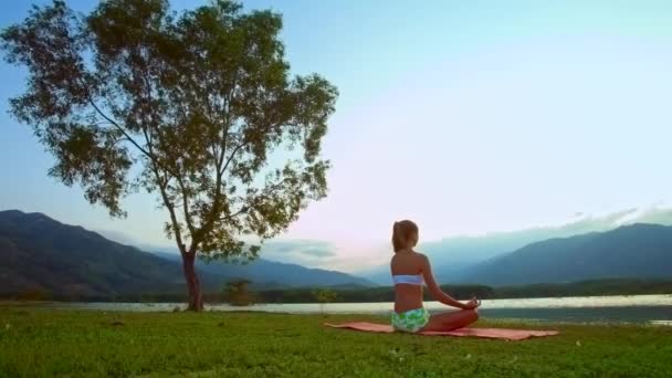 Mujer Joven Está Sentada Alfombra Meditando Orilla Del Río — Vídeos de Stock