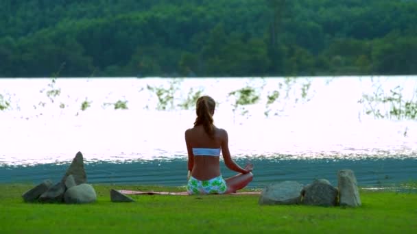 Junge Frau Sitzt Auf Teppich Und Meditiert Flussufer — Stockvideo