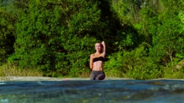 İnek yüz yoga poz mavi su yakınında ince kız meditasyon