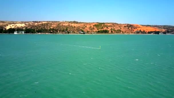 Deportista distante windsurf en el océano contra la orilla del mar — Vídeos de Stock