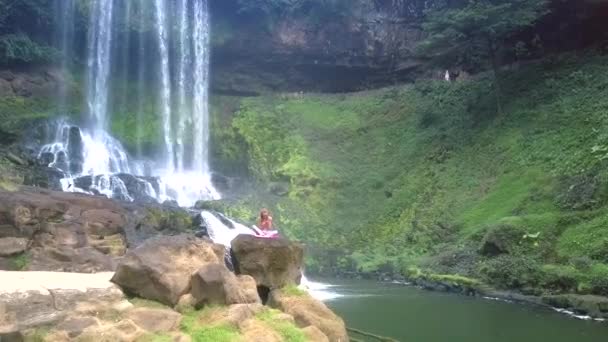 Fliegenkamera nähert sich Frau auf Felsen im Naturschutzgebiet — Stockvideo