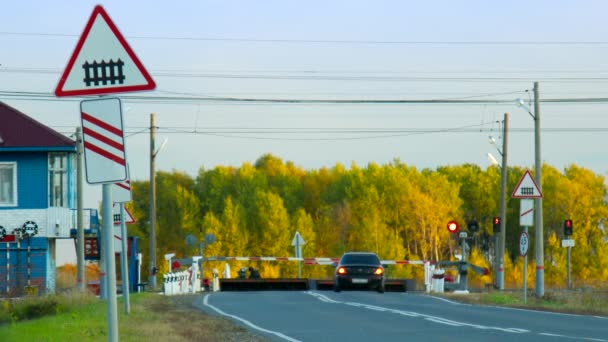 Travessia ferroviária com sinal de estrada contra a floresta amarela — Vídeo de Stock