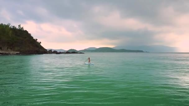 Bewegung zur Dame auf dem Paddleboard beim Surfen im grenzenlosen Ozean — Stockvideo