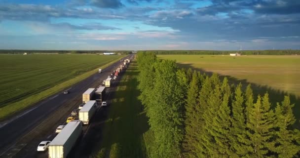 Довгий ряд повільно рухатися автомобілі вздовж дороги серед краєвид — стокове відео