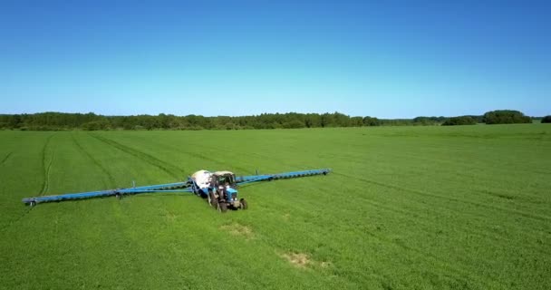 Traktor penyemprotan tanaman hijau drive ke kamera terhadap hutan — Stok Video