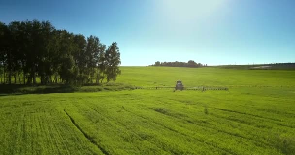 Rociador arrastrado conduce arboleda redonda al siguiente campo verde — Vídeo de stock