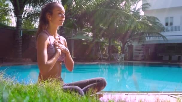 Lady in yoga pose relaxes putting hands on chest side view — Stock Video