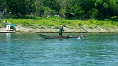 adam yosun nehir alt yüzer sopa ile teknede çeker.
