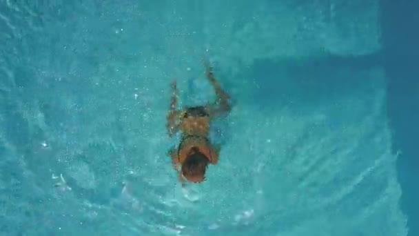 Lady swims in swimming pool making ripples — Stock Video