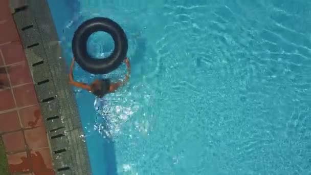 Fille prend bouée de sauvetage à la piscine pour nager et se détendre sous les rayons du soleil — Video