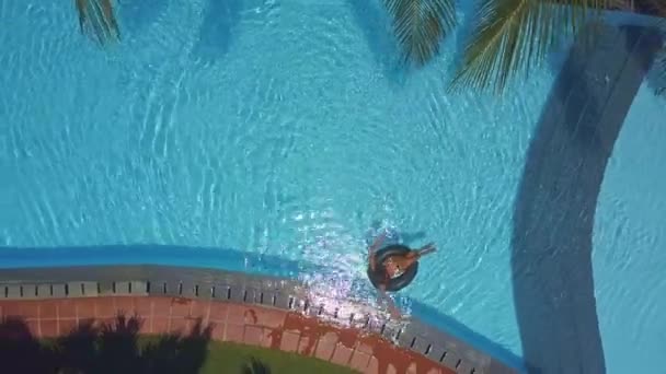 Леді плаває на кільці біля басейну бар'єру — стокове відео