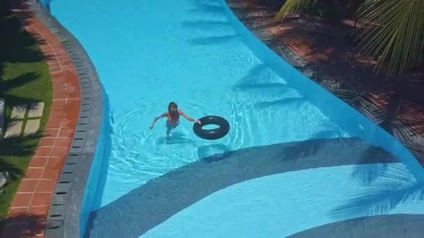 Blond flicka i bikini går ur poolen med ring — Stockvideo