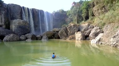 Yerel adam balıkların su birikintisi yakın şelale