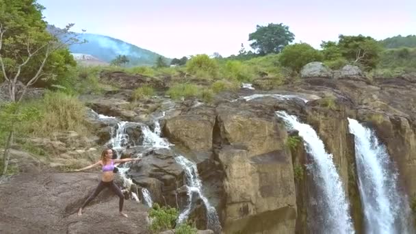 Dívka stojí v jóga představuje na plochý kámen rozbití — Stock video