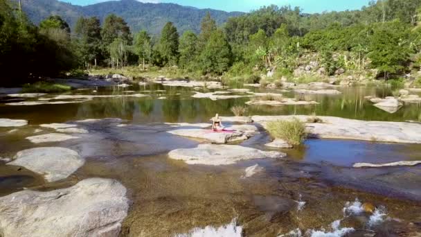 Donna siede in posa yoga contro giungla sconfinata — Video Stock