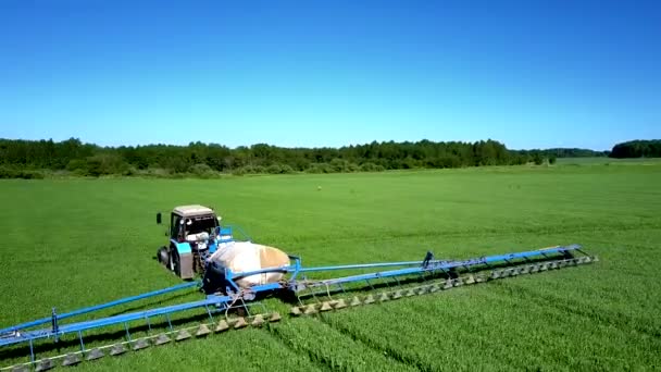 Vista aérea tractor asperja campo de colza con productos químicos — Vídeo de stock