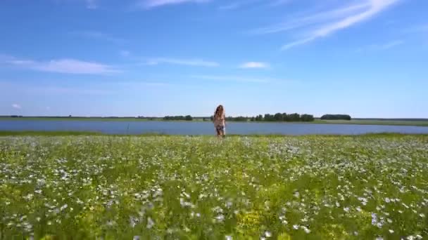 Счастливая улыбающаяся девушка бежит по цветущему гречневому полю — стоковое видео