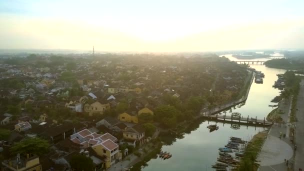 Vlucht boven de rivier met bruggen boten in de oude stad Hoian — Stockvideo