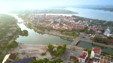 büyüleyici görünümü Hoi palmiye ağaçları ve kırmızı çatı arasında merkezi bir kare karşı geniş nehir evler