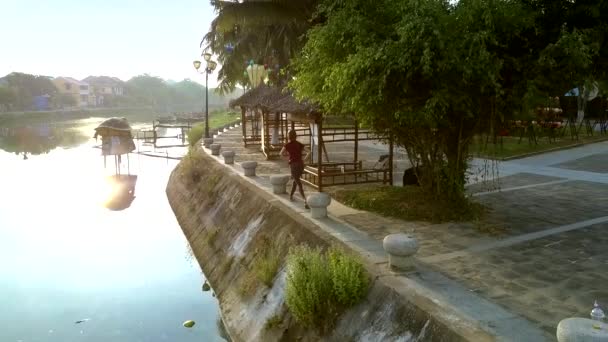 Стройная девушка делает упражнения на берегу канала — стоковое видео