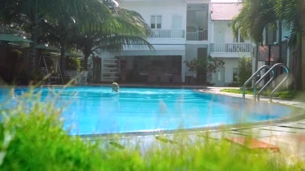 Жінка плаває в гарному готелі маленький басейн серед долонь — стокове відео