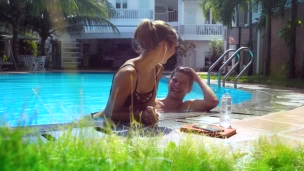 European guy and girl laugh having fun by pool barrier — Stock Video