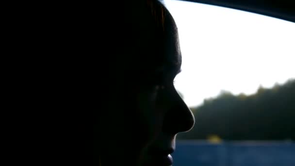 Close up girl profile lit by sun against passing traffic — Vídeo de Stock