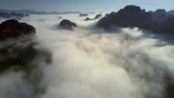 Vuelo alto por encima de las cimas de las montañas visto en nubes de niebla blanca — Vídeos de Stock