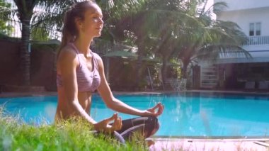 Lotus poz çekici Bayan havuzu tarafından diz ellerini koyar