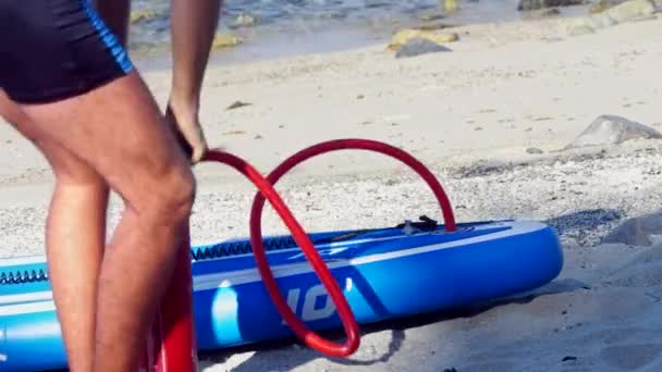 Kille pumpar långsamt paddle board på stranden låg vinkel skott — Stockvideo