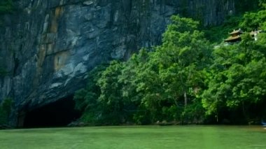 nehir gri cliff yeşil ağaçları ve adam gemide görüntülemek