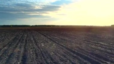 gün batımında sınırsız sürülmüş alanının üstündeki hızlı uçuş