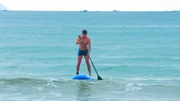 Homem Aproxima Praia Oceano Prancha Remo Contra Maravilhosa Paisagem Marinha — Vídeo de Stock