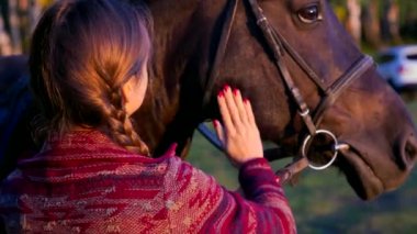 Kırmızı manikür kontur kahverengi at yüz ve boyun araba'nın bahçesinde karşı yan görünümü sarışın kız elleriyle akşamları kapatın