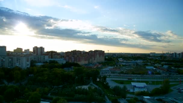 高層ビルや公園で大規模な近代的な都市の上の白い雲と空と夕日 — ストック動画