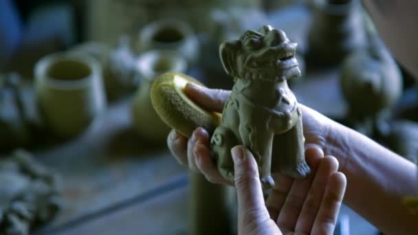 Makro kvinna händer ren lera hund skulptur med svamp — Stockvideo