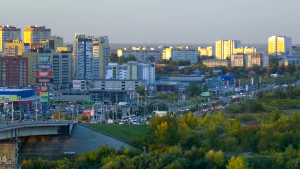 Интенсивное движение по городской автомагистрали между зданиями и парком — стоковое видео