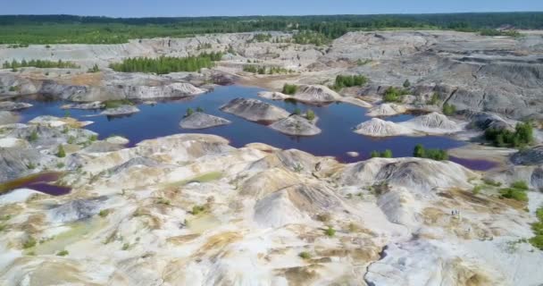 Vista superior velho fosso de argila com lagos por floresta sob céu azul — Vídeo de Stock