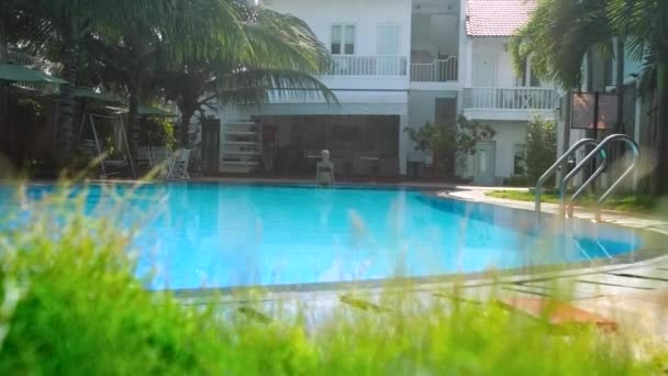 Красивый отель небольшой бассейн и женщина начинает плавать — стоковое видео